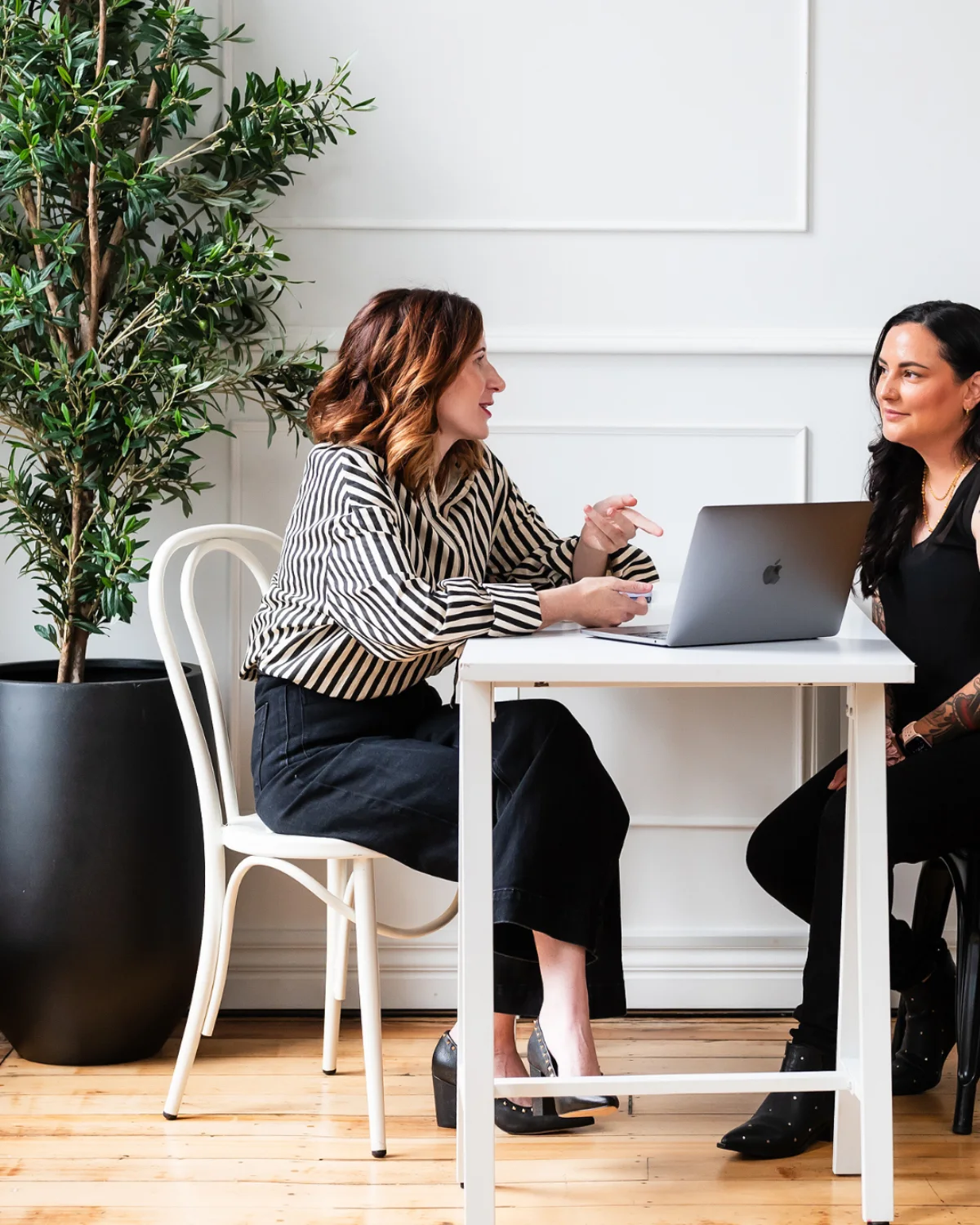 Rachel Gronback at a table with a client, laptop open, mid-conversation